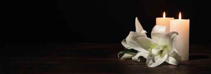 Burning candles and flowers on black background with space for text. Funeral concept - obrazy, fototapety, plakaty