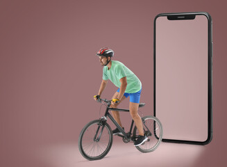 Male cyclist with bicycle and modern mobile phone on color background