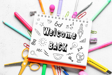 Notebook with text WELCOME BACK and school stationery on light background