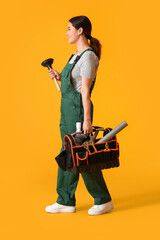 Asian female plumber holding bag with tools on yellow background