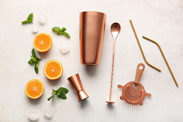 Copper cocktail utensils and ingredients on light background