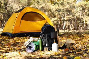 Fototapete Camping Tourist's survival kit and camping tent in autumn forest