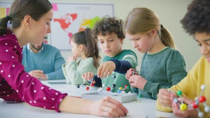 Multi-cultural students with teachers in classroom studying molecular model in science class - shot in slow motion - Powered by Adobe