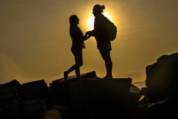 sun set dos personas en la playa contra luz