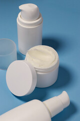 close up of mock up white jar with cream on a blue background