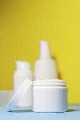 mock up of white jar of cream on a yellow background. Ready place for the label, copy space