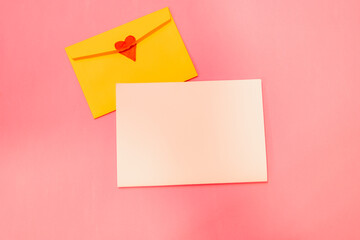 
Greeting card mockup with yellow envelope with heart on pink background