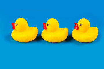Three toy ducklings on a blue background.