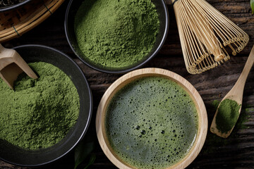Japanese organic matcha green tea powder in bowl with wire whisk and green tea leaf on wooden background, Organic product from the nature for healthy with traditional style