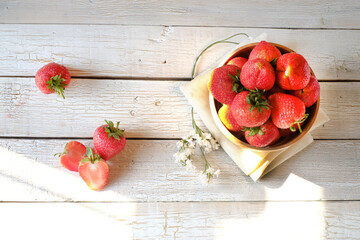 Fresh ripe red strawberries in wooden cup and whitecloth on  bokeh background, natural rustic food,fruit,top view