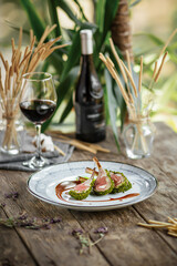 Plate of gourmet lamb cutlet ribs with sauce and red wine