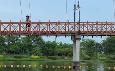 man and woman walking on a bridge over water