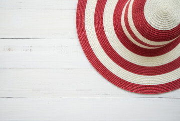 Fototapeta na wymiar Large red lady beach hat on white wooden background with copy space. Travel summer beach holiday concept.