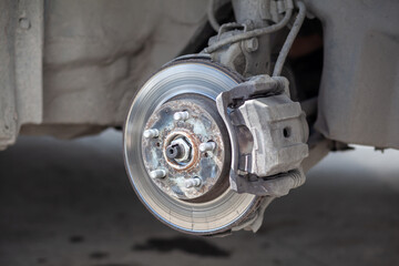 Disc brake of the vehicle for repair, in process of new tire replacement. Car brake repairing in...