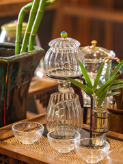 A glass teapot and cups set on a wooden tray