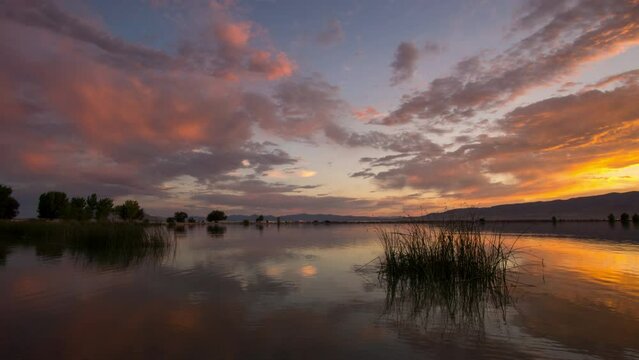 Time lapse reflecting colorful sunset in Utah Lake as the color fades away.