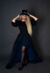 Beautiful Halloween Make-Up Style. Blond curly hair Model Wear Sugar Skull Makeup with Red Roses. Santa Muerte concept. Model on black background in studio in a hat