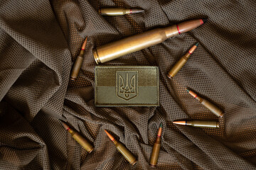 Pili lie on a green background and next to it lies a stripe with the flag of Ukraine, the war in Ukraine, ammunition