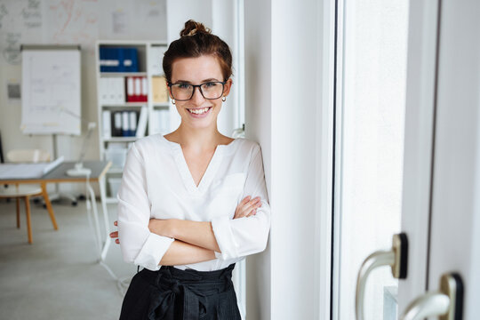 businesswoman with glasses in office looks to camera