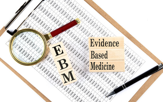 EBM - Evidence-based medicine text on wooden block on chart background