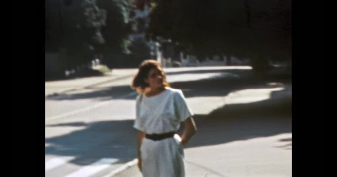 Young woman on sunny city street, summer. Stylish, caucasian woman traveling, walking by Europe city center. Person views landmarks. Vintage color film. Grey urban archive. Retro 1980s Kyiv Ukraine 
