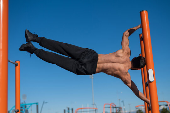 Shirtless Man Doing Human Flag Outdoors. 