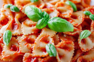 Farfalle, cooked pasta with tomato sauce and basil green leaves, close-up, selective focus.