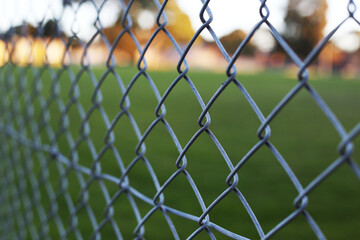 Fototapeta premium Chain link fence, steel metal industrial pattern in court, selective focus
