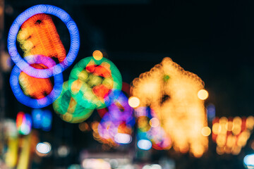 Blurry and defocused multicolored lights of an amusement park in the night.