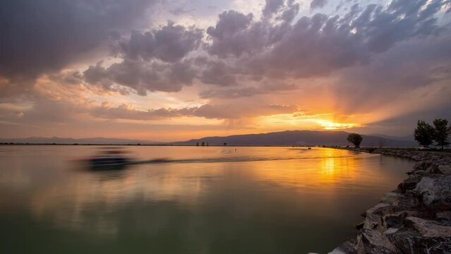Sunset time lapse of boats coming into harbor at Utah Lake as the colorful sky fades into dusk.
