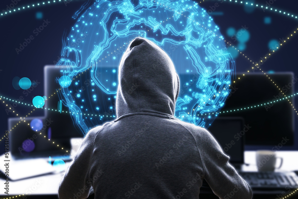 Poster hacker at desktop using laptop with bright globe hologram. A holographic projection of planet earth. Flickering energy particles on blurry abstract dark background. 