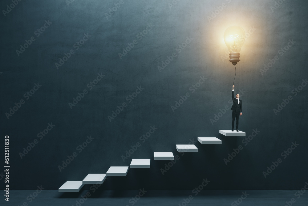 Aufkleber Innovation and idea concept with front view on businessman in suit on the top of white stairway turning on big light bulb on dark concrete background in empty hall