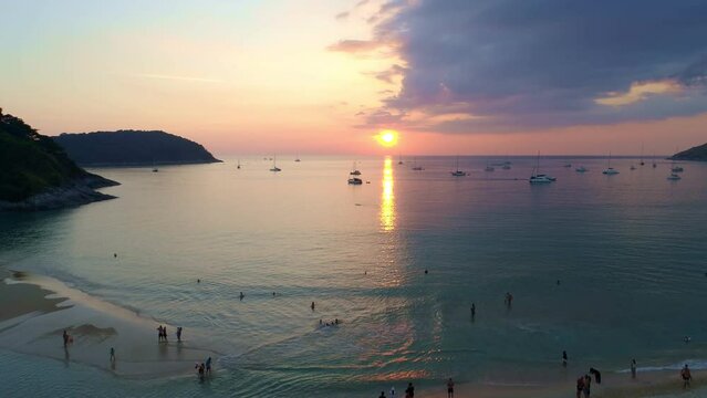 Colorful sunset above the sea surface with sail boats Aerial view drone fly over Phuket sea Reflected sun golden light on a water surface Sunset over ocean Seascape Summer and travel vacation concept