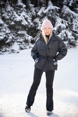 beautiful blonde woman in pink hat in winter snow forest