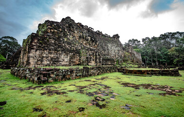 Fototapeta na wymiar Baphoun Castle on the west side, sandstone is arranged to form a large reclining Buddha image at Baphoun Temple, Angkor Thom, Siem Reap, Cambodia.
