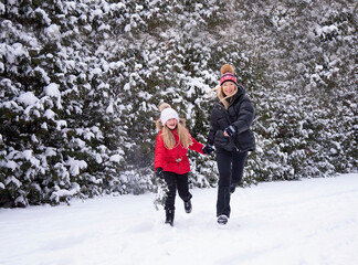 beautiful blonde mother with daughter having fun in winter park