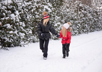 Fototapeta na wymiar beautiful blonde mother with daughter having fun in winter park
