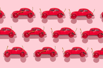 Summer creative pattern with toy car and bright red cherries on pastel pink background. 80s or 90s...