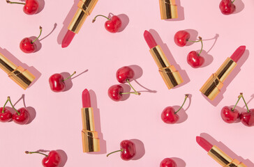 Summer creative pattern with bright red cherries and golden lipstick on pastel pink background. 80s or 90s retro aesthetic idea. Minimal summer fashion idea. - obrazy, fototapety, plakaty