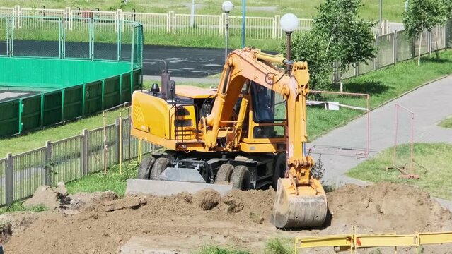 excavator digs a hole for laying communications