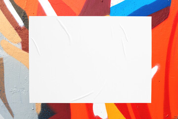 Closeup of colorful orange red beige gray blue painted urban wall texture with wrinkled glued poster template. Modern mockup for design presentation. Creative urban city background. 