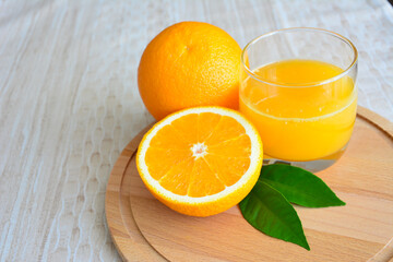 orange juice in drinking glass on cutting board, close-up