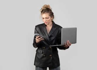 Business serious woman in black fashion dress with laptop and phone. Business concept.