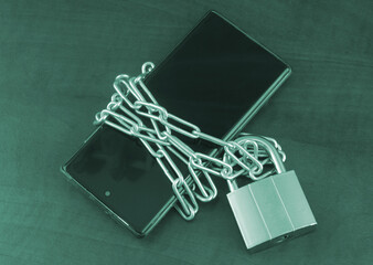 Protected data concept. Chained smartphone with padlock close-up.	