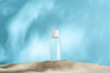 clean small bottle of micellar water, facial toner on the sand