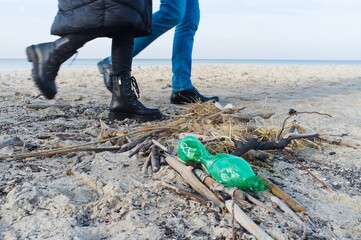 peoples crossing green plastic bottle  rubbish at baltic coast