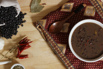Black Bean Chili on Wooden Table With Spices and Dried Black Beans
