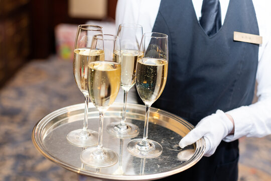 Waitress holding tray with glasses of champagne at party