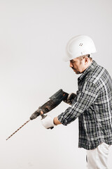 Male builder in a hard hat with a puncher on a white background