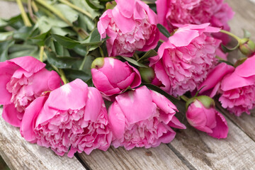 beautiful bouquet of pink peonies on a wooden background